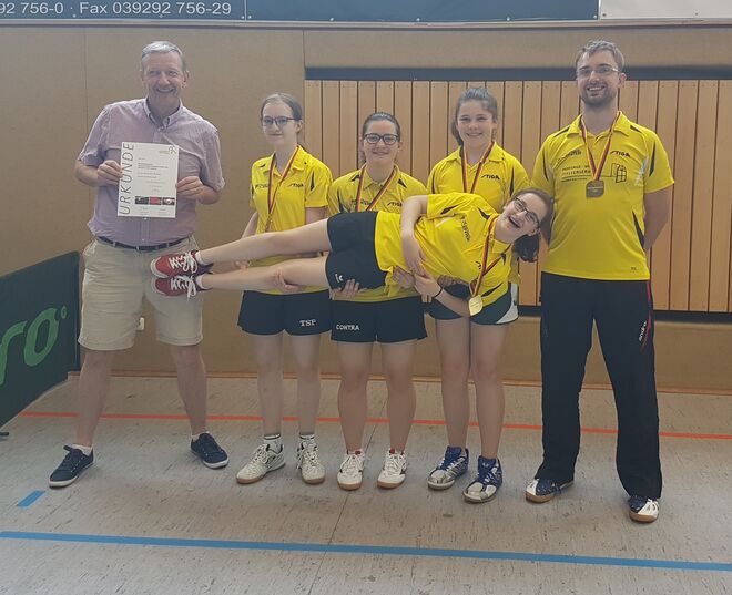 Die Trainer Thomas Fischer (li.) und  Ronny Gursinsky mit den Meisterinnen Maja Adam, Amélie Mocker, Leonie Hildebrandt, (v.l.) und der "schwebenden" Finja Adam.